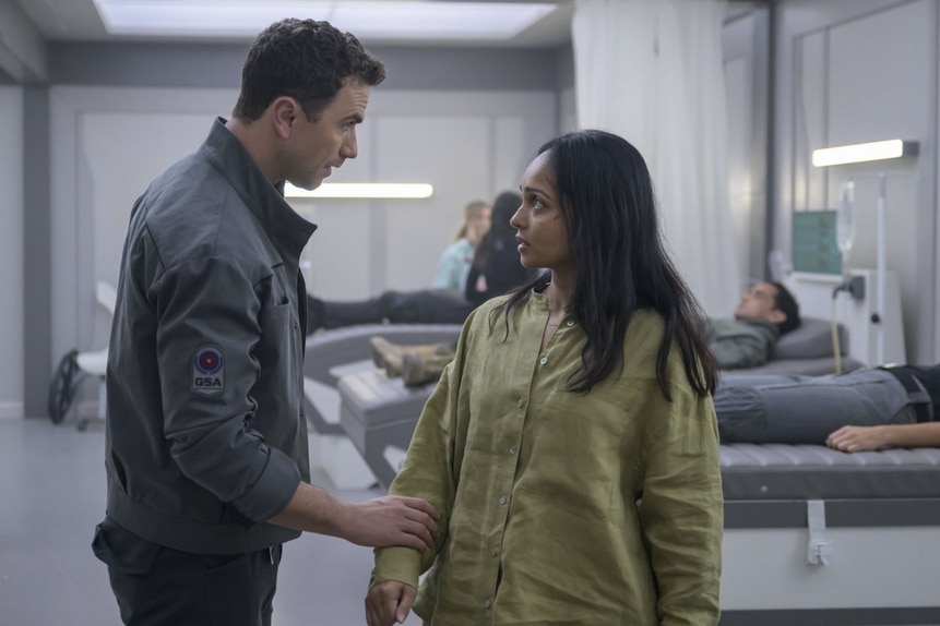 Lt. James Brice (Richard Fleeshman) grips Dr. Sanjivni Kabir's (Shalini Peiris) arm in The Ark Episode 210.