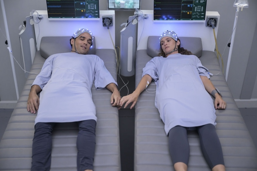 Ian (Reece Ritchie) and Lt. Sharon Garnet (Christie Burke) hold hands in hospital beds in The Ark Episode 210.