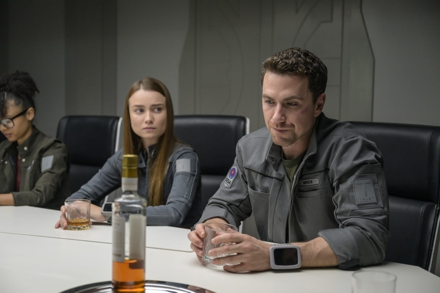 Alicia Nevins (Stacey Read), Eva Markovic (Tiana Upcheva), and Lt. James Brice (Richard Fleeshman) sit at a table together on The Ark Episode 210.