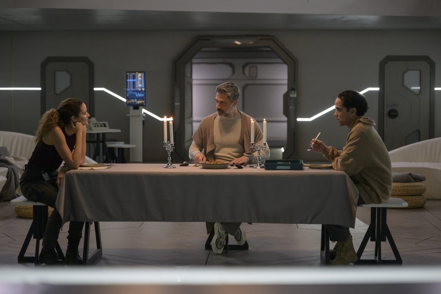 Lt. Sharon Garnet (Christie Burke) and Dr. Marsh (Jadran Malkovich), and Ian (Reece Ritchie) sit at different sides of a long table in The Ark Episode 210.