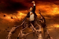 John Constantine (Keanu Reeves) is pulled by ghouls in a fiery hellscape in Constantine (2005).