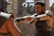 Maximus (Russell Crowe) sticks two swords in an opponent in Gladiator (2000).