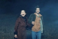 Itsy Levan (Emma Tremblay) and Calvin Kipler (Jacob Buster) look up at a bright object in the air in Aliens Abducted My Parents And Now I Feel Kinda Left Out (2023).