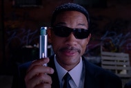 Agent J (Will Smith) holds up a silver device in Men in Black 3 (2012).