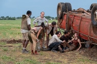 The cast of twisters tend to Kate next to a flipped over car in Twisters