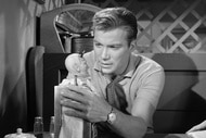 Don Carter (William Shatner) holds a horned figurine on The Twilight Zone.