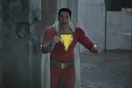 Shazam (Zachary Levi) wears a red outfit with a bid glowing yellow triangle in SHAZAM! (2019).