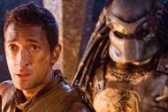 A predator sneaks behind Royce (Adrien Brody) in Predators (2010).