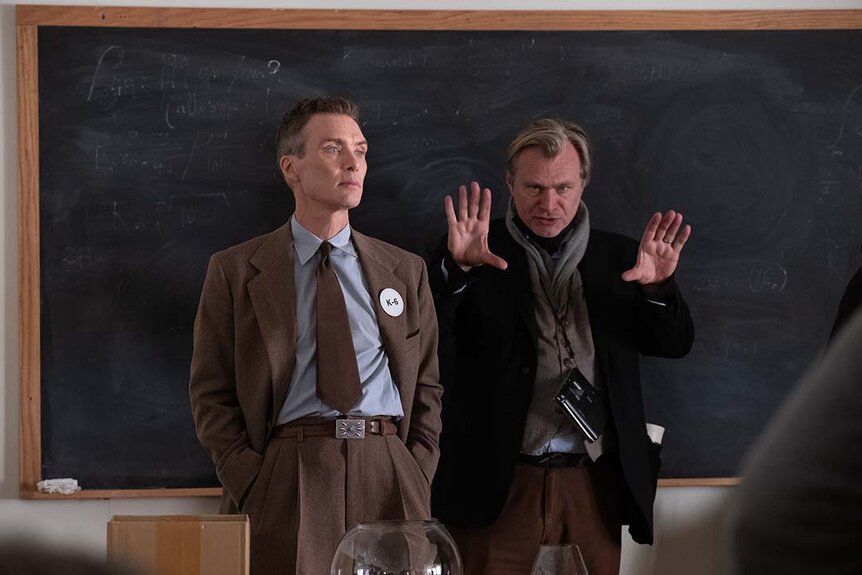 (L to R) Cillian Murphy and Christopher Nolan work on the set of Oppenheimer (2023).