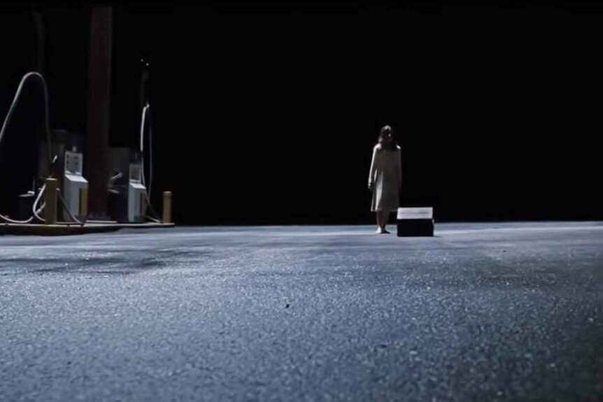 Em (Natasha Calis) stands in front of a box at a gas station lot in The Possession (2012).