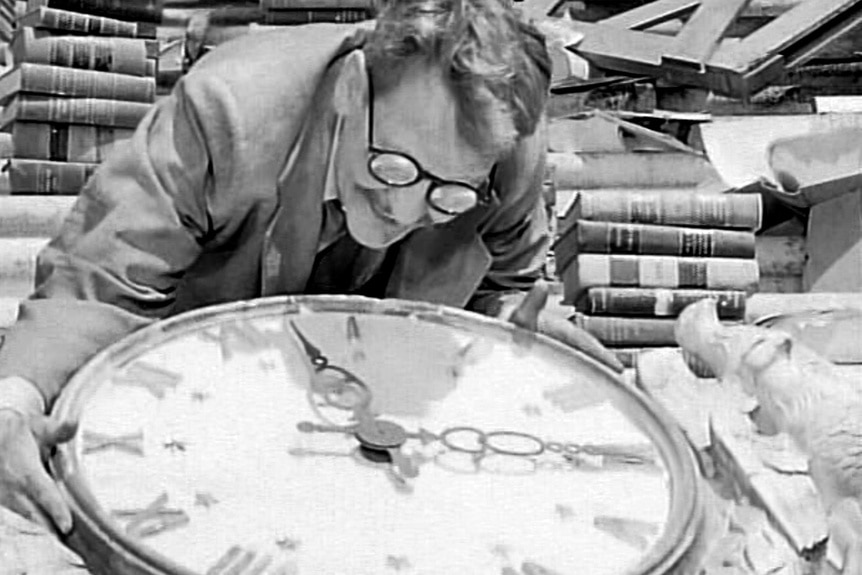 Henry Bemis (Burgess Meredith) hugs a large clock face in The Twilight Zone episode, "Time Enough At Last."