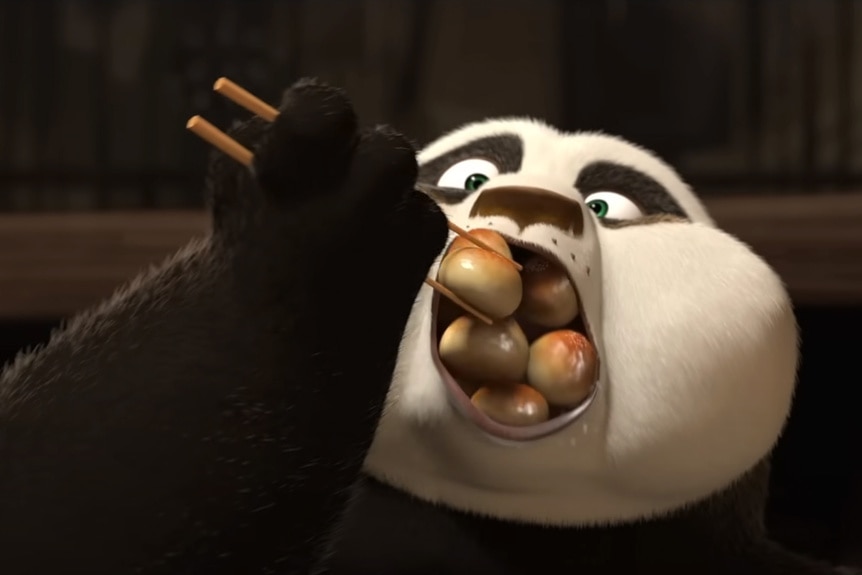 Po (Jack Black) uses chopsticks to push many dumplings in his mouth in Kung Fu Panda 2 (2011).