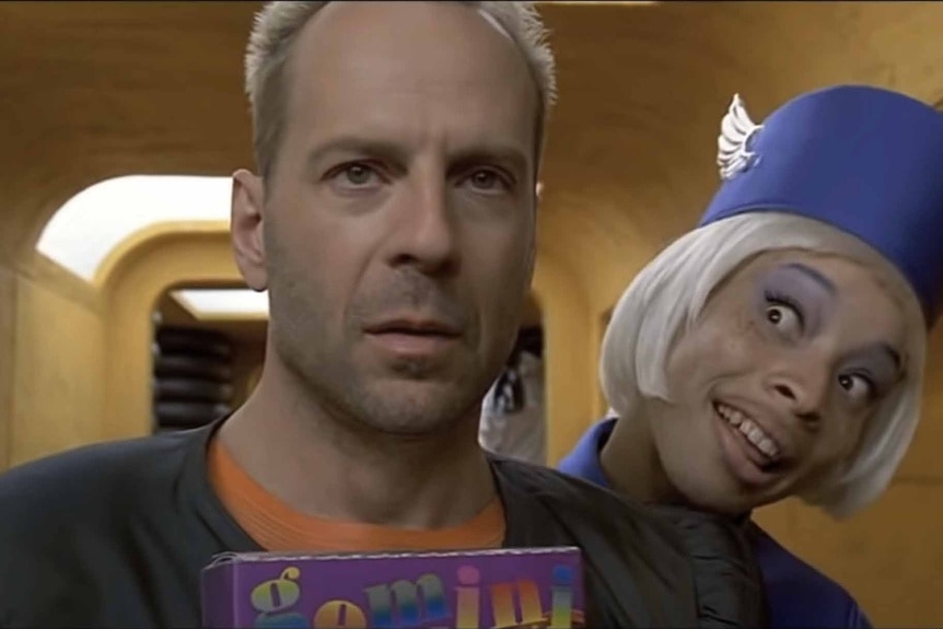 Korben (Bruce Willis) and a attendant in a blue hat appear in The Fifth Element (1997).