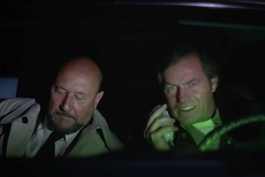 Loomis (Donald Pleasence) and Sheriff Brackett (Charles Cyphers) ride in a car in Halloween II (1981).