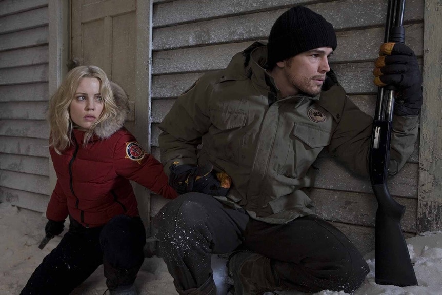 Stella Oleson (Melissa George) and Eben Oleson (Josh Hartnett) sneak around a corner in 30 Days of Night (2007).