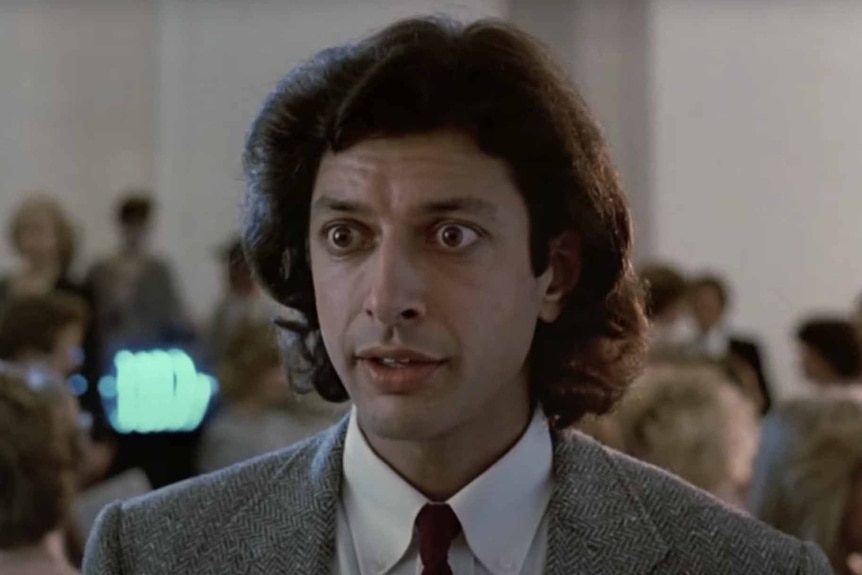 Seth Brundle (Jeff Goldblum) wears a suit and tie in The Fly (1986).