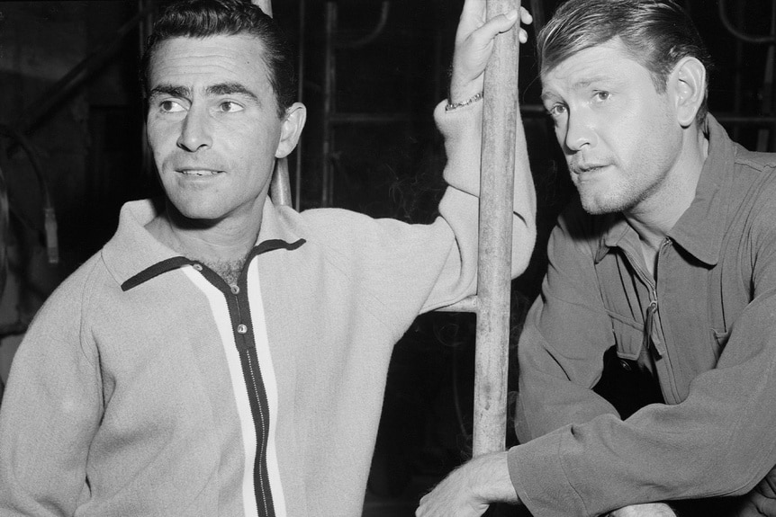 Rod Serling leans on a pole next to Earl Holliman on the set of The Twilight Zone Episode 101.