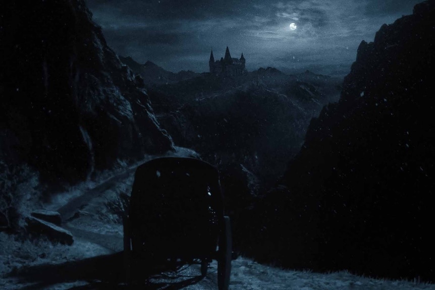 A carriage approaches Orlok’s castle in the dark in Nosferatu (2024).