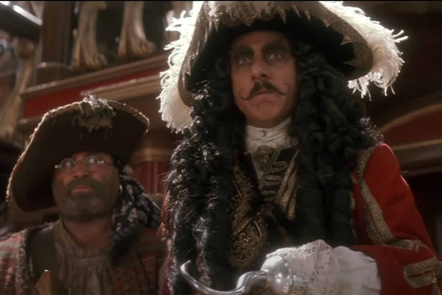 Mr. Smee (Bob Hoskins) and Captain Hook (Dustin Hoffman) wear large hats in Hook (1991).