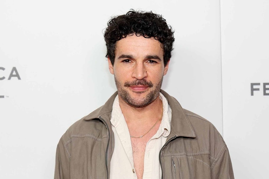 Christopher Abbott wears a tan jacket.