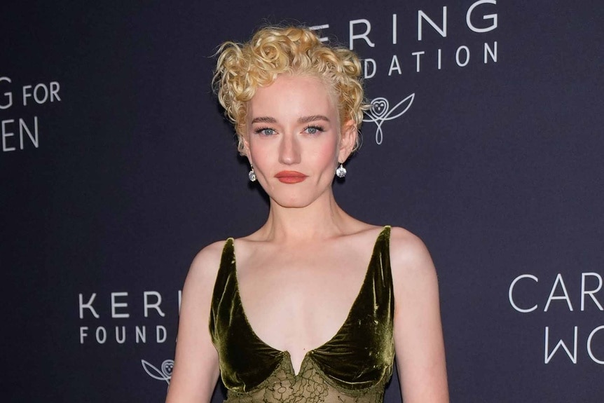 Julia Garner wears a metallic dress.